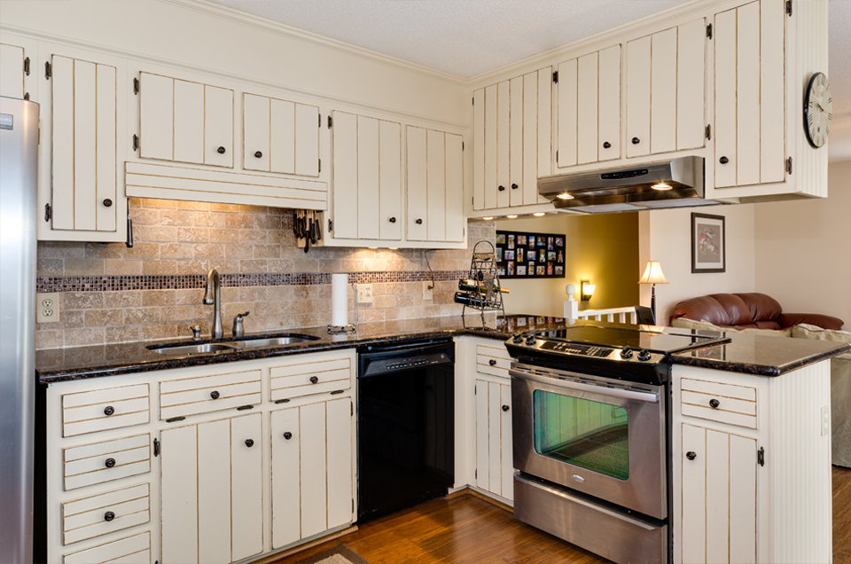 A beautiful kitchen featuring a stine back splash. This lake house is located on Badin Lake, in New London NC. Real Estate photoshoot by Esjay Media.